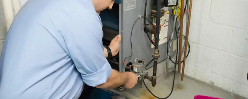 Furnace repair technician inspecting and servicing a home heating system in Stockton, CA
