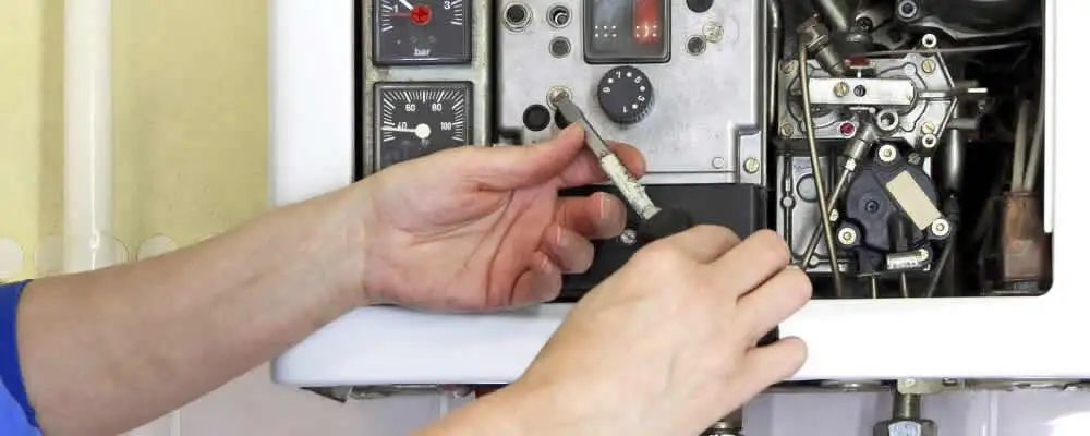 Heating repair technician adjusting boiler controls and components in Stockton, CA