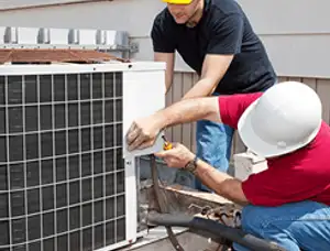 HVAC technicians repairing an outdoor AC unit on a rooftop in Stockton, CA