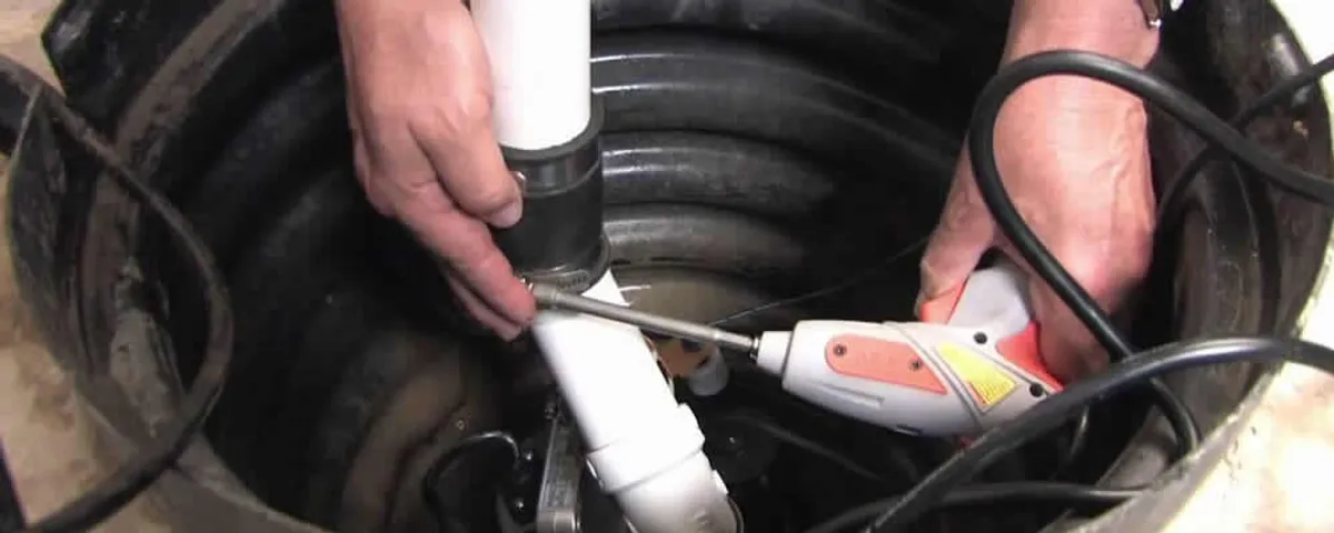 Sump pump installation technician connecting PVC discharge piping in Stockton, CA