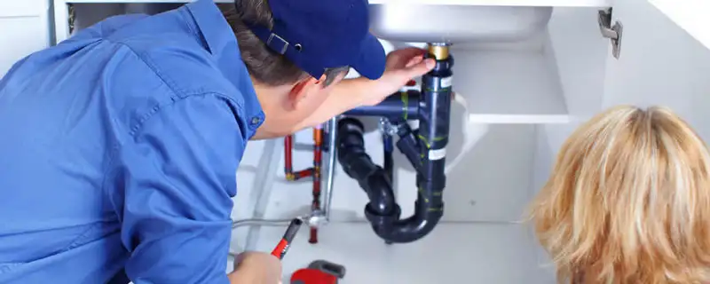 Plumber repairing under-sink drain pipes and fittings in Stockton, CA